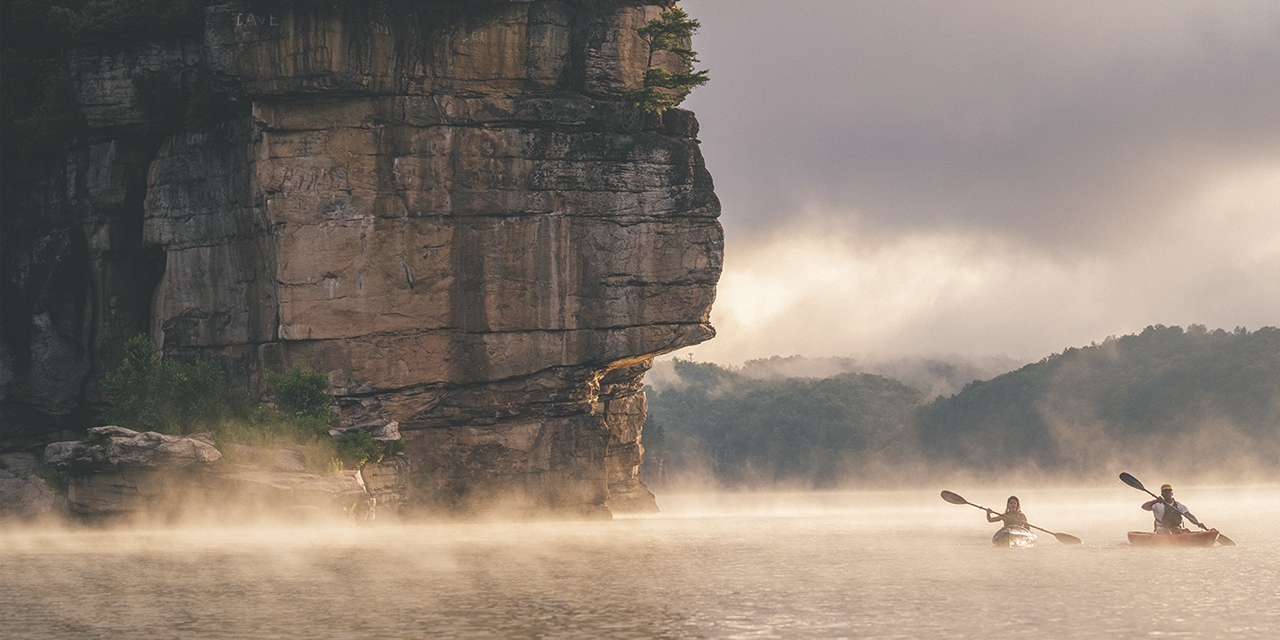 people kayaking in the fog