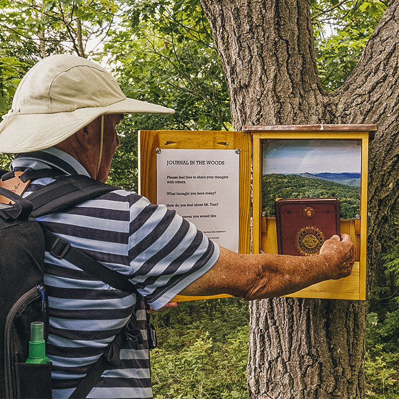 A man reading a trail journal along the New England trail