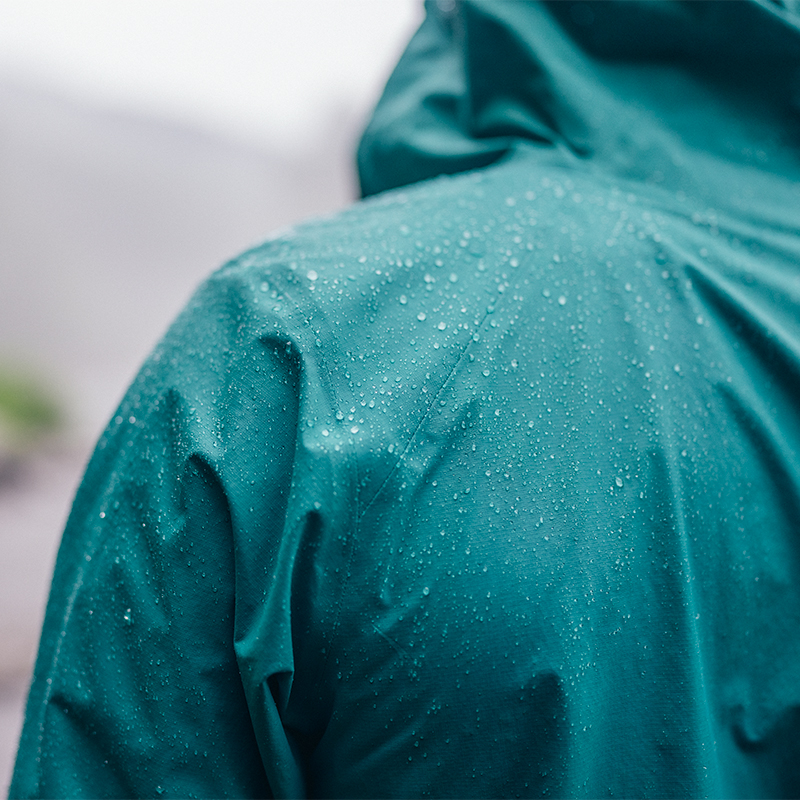 A close up on a rain jacket with rain droplets on it
