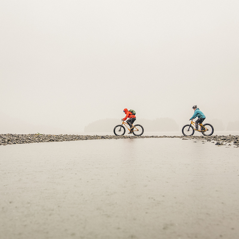 Two people biking in the rain